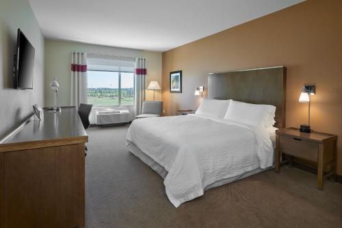 a hotel room with a large bed and a window at Four Points by Sheraton Sherwood Park in Sherwood Park
