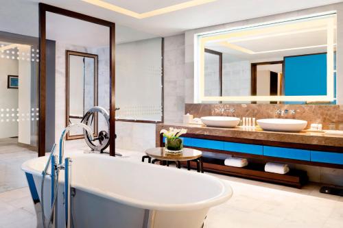 達卡的住宿－達卡艾美度假酒店，浴室配有2个盥洗盆和1个浴缸。