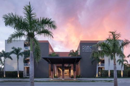 een gebouw met palmbomen ervoor bij Four Points by Sheraton  in Punta Cana