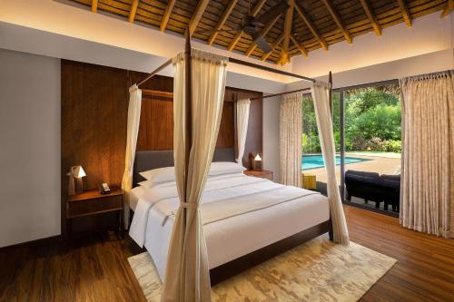 1 dormitorio con cama y piscina en Sheraton Grand Chennai Resort & Spa, en Mahabalipuram