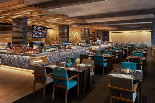 a rendering of a restaurant with tables and chairs at Sheraton Grand Chennai Resort & Spa in Mahabalipuram