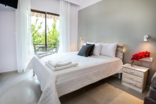 a bedroom with a large white bed with a window at Mani’s studios in Skala Sotiros