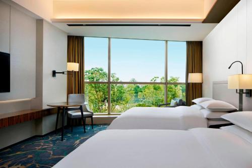 Sheraton Shanghai Chongming Hotel في Chongming: غرفة فندقية بسريرين ونافذة