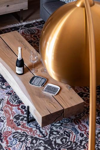 a wooden coffee table with a bottle of wine and a glass at Sella&Mosca Casa Villamarina in Alghero