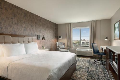 a hotel room with a bed and a desk and chair at Four Points by Sheraton Sacramento Airport in Sacramento