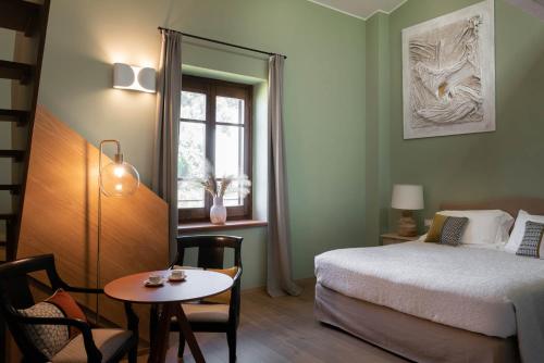 sypialnia z łóżkiem, stołem i oknem w obiekcie Sella&Mosca Casa Villamarina w mieście Alghero
