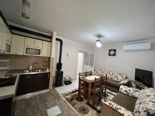 een woonkamer met een bank, een tafel en een keuken bij Home Shkodra Center in Shkodër