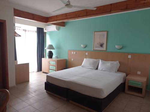 ein Schlafzimmer mit einem Bett und einer blauen Wand in der Unterkunft The San Anton Hotel in St Paul's Bay