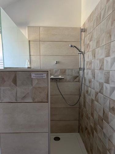 a shower with a glass door in a bathroom at Mas Escombelle in Barjac