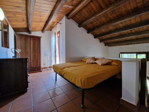 a bedroom with a bed in a room with wooden ceilings at Casa vacanze Dafne in Mandra Capreria