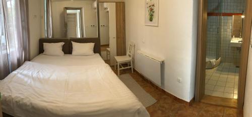a bedroom with a white bed and a bathroom at Aparthotel Cross Street 4 in Ljubljana