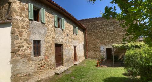 an old stone building with green shutters on it at Bargi in Lugnano