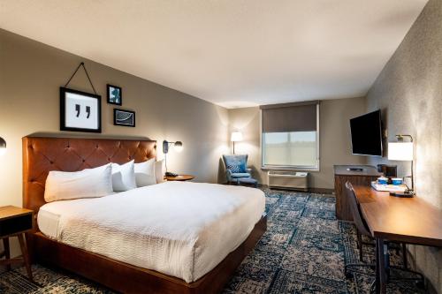 um quarto de hotel com uma cama, uma secretária e uma televisão em Four Points by Sheraton St. Louis - Fairview Heights em Fairview Heights