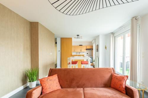 un salon avec un canapé marron et une cuisine dans l'établissement Terracotta, chaleureux appartement calme pour 2 personnes, avec Parking privé, idéal séjour business, à Dijon