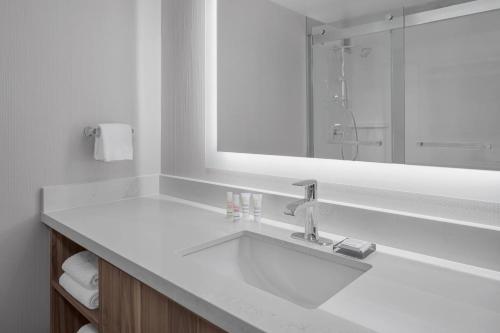 a white bathroom with a sink and a mirror at Pleasanton Marriott in Pleasanton