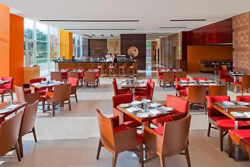 a restaurant with tables and chairs and a bar at Fairfield by Marriott Lucknow in Lucknow