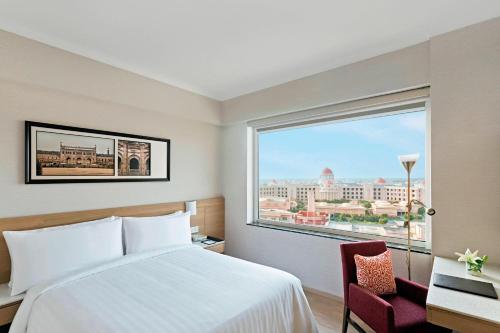 a hotel room with a bed and a large window at Fairfield by Marriott Lucknow in Lucknow