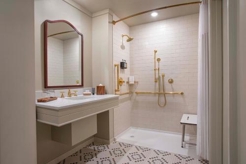 a white bathroom with a sink and a shower at Grand Adirondack Hotel, Lake Placid, a Tribute Portfolio Hotel in Lake Placid