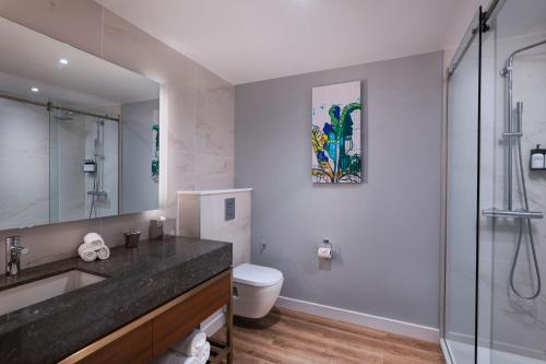 a bathroom with a sink and a toilet and a shower at The BRIX Autograph Collection in Port-of-Spain