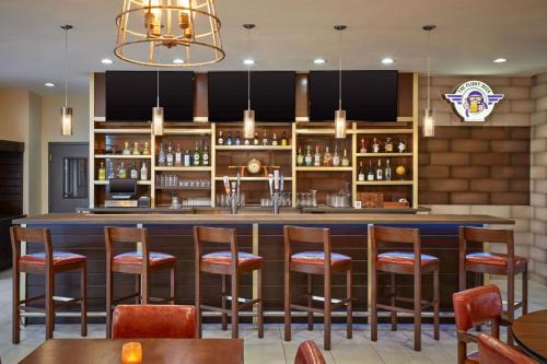 a bar in a restaurant with wooden stools at Four Points by Sheraton Houston Intercontinental Airport in Houston