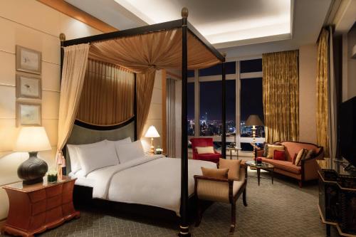 a bedroom with a canopy bed and a living room at JW Marriott Shanghai at Tomorrow Square in Shanghai
