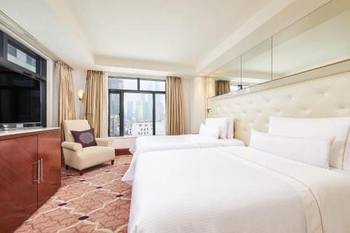 a hotel room with two beds and a television at The Westin Bund Center, Shanghai in Shanghai