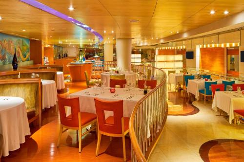a dining room with white tables and chairs and a restaurant at The Westin Bund Center, Shanghai in Shanghai