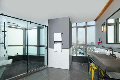 a bathroom with a shower and a sink at Moxy Shanghai Xuhui in Shanghai