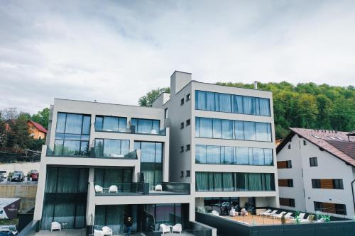 um grande edifício branco com janelas de vidro em Fabesca Boutique Hotel & SPA em Sovata