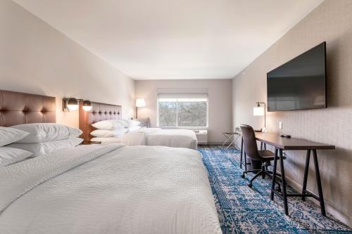 Habitación de hotel con 2 camas y escritorio en Four Points by Sheraton Elkhart en Elkhart