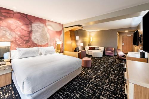 una camera d'albergo con letto e soggiorno di Courtyard Winston-Salem Downtown a Winston-Salem