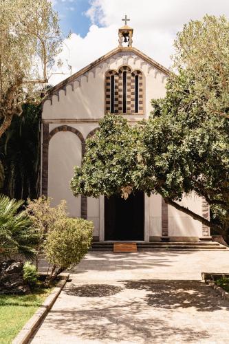 a white church with a cross on top of it at Sella&Mosca Casa Villamarina in Alghero