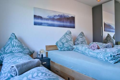 - une chambre avec 2 lits dotés d'oreillers bleus dans l'établissement Stilvolle 2 Schlafzimmer Apartments Heidegarten, Osterheide, Zentrum, à Schneverdingen