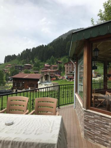 a patio with a table and chairs on a balcony at Guesthouse Dolunay in Ayder Yaylasi