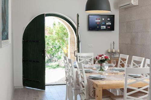 a dining room with a green door and a table and chairs at Charming stone villa Silva in Tučepi