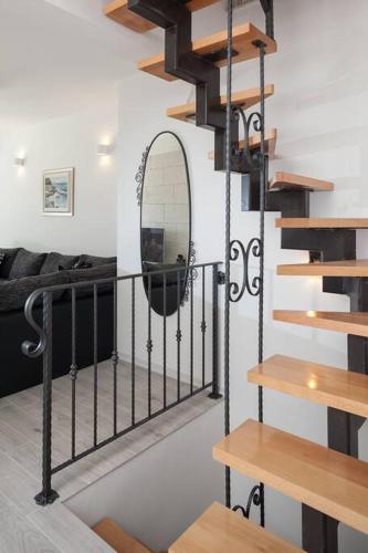 a spiral staircase in a living room with a mirror at Charming stone villa Silva in Tučepi