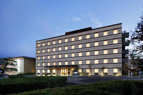 宮津的住宿－Fairfield by Marriott Kyoto Amanohashidate，一座大型办公楼,在黄昏时分有很多窗户