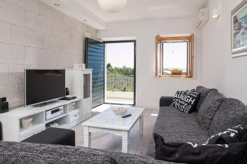 a living room with a couch and a tv at Charming stone villa Silva in Tučepi