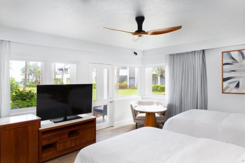 a hotel room with two beds and a flat screen tv at Sheraton Fiji Golf & Beach Resort in Denarau