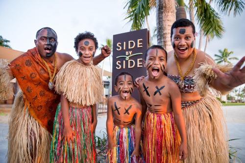 a group of people in costumes posing for a picture at Sheraton Fiji Golf & Beach Resort in Denarau