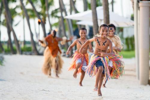 a group of young children performing a dance on the beach at Sheraton Fiji Golf & Beach Resort in Denarau