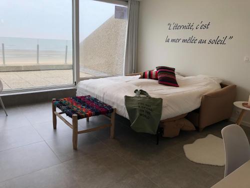 een bed in een kamer met uitzicht op de oceaan bij Mayfair 0205 exclusive residence with sea view in De Haan