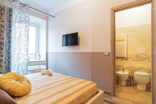 a bedroom with a bed and a toilet and a television at Royal Rooms - Elegante appartamento nel cuore di Roma in Rome