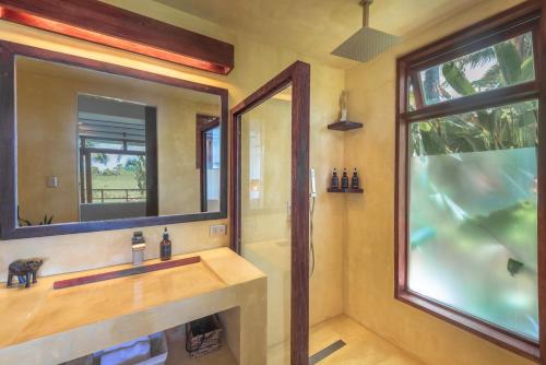 een badkamer met een wastafel en een spiegel bij Tanaw Villas in General Luna