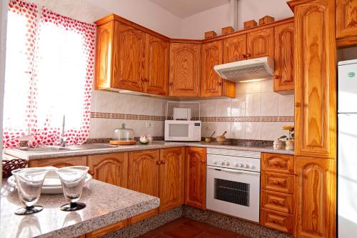 cocina con armarios de madera y horno de fogón blanco en Casa Canaria Vistas al Mar, en Santa Cruz de la Palma