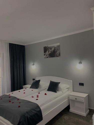 a bedroom with a bed with red roses on it at Pensiunea Nobless Eșelnița in Eşelniţa