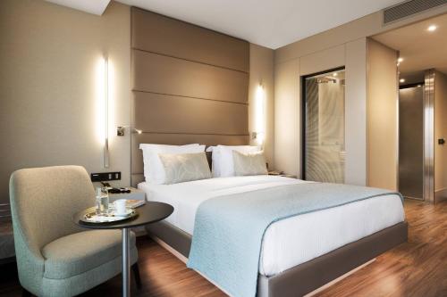 una camera con letto, tavolo e sedia di AC Hotel Istanbul Macka a Istanbul