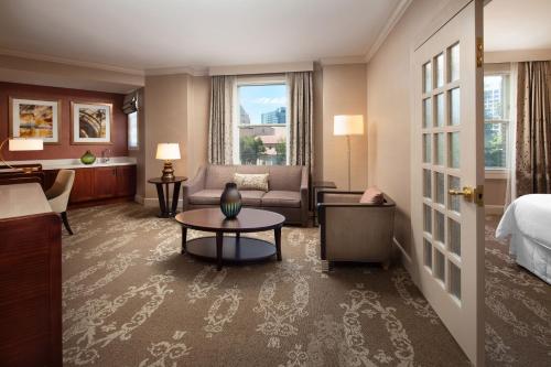 サンノゼにあるザ ウェスティン サン ホゼのベッド、ソファ、テーブルが備わるホテルルームです。