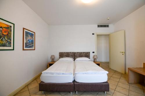 a bedroom with a large bed in a room at Aquazzurra Resort & Aparthotel in Cannobio