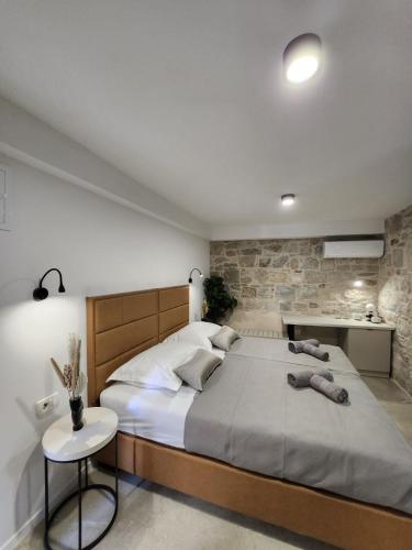 a bedroom with a large bed and a stone wall at Rio Luxury Rooms in Split
